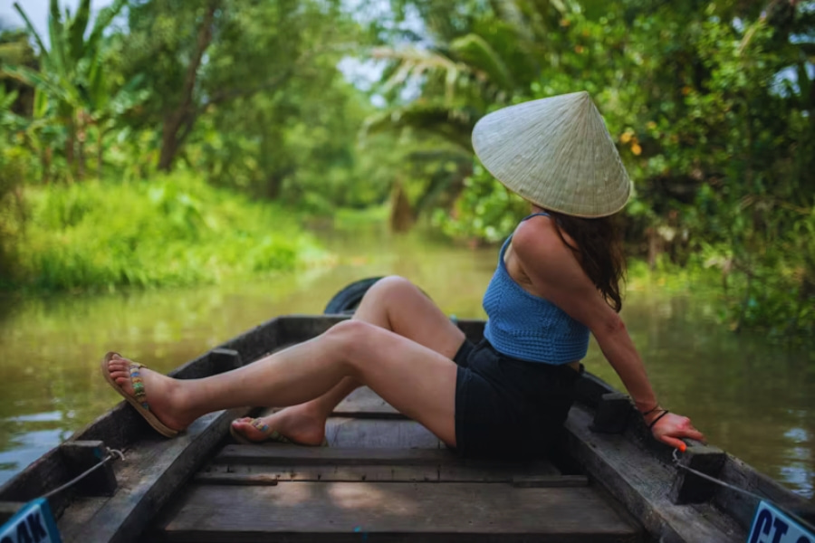 Female solo travel Vietnam relaxing on a boat in the Mekong Delta